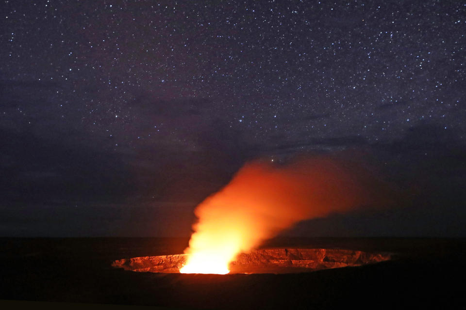 <p>Stars shine above as a plume rises from the Halemaumau crater, illuminated by glow from the crater’s lava lake, within the Kilauea volcano summit at the Hawaii Volcanoes National Park on May 9, 2018 in Hawaii Volcanoes National Park, Hawaii. (Photo: Mario Tama/Getty Images) </p>