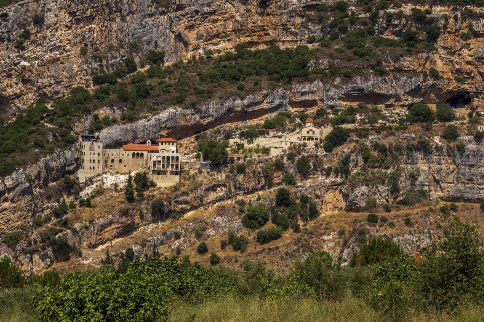 The Hammatoura Monastery is one of many monasteries that built on a hill inside the scenic Kadisha Valley, considered a holy site to Lebanon's Maronite Christians, in the northeast mountain town of Kousba, Lebanon, Sunday, July 23, 2023. For Lebanon's Christians, the cedars are sacred, these tough evergreen trees that survive the mountain's harsh snowy winters. They point out with pride that Lebanon's cedars are mentioned 103 times in the Bible. (AP Photo/Hassan Ammar)