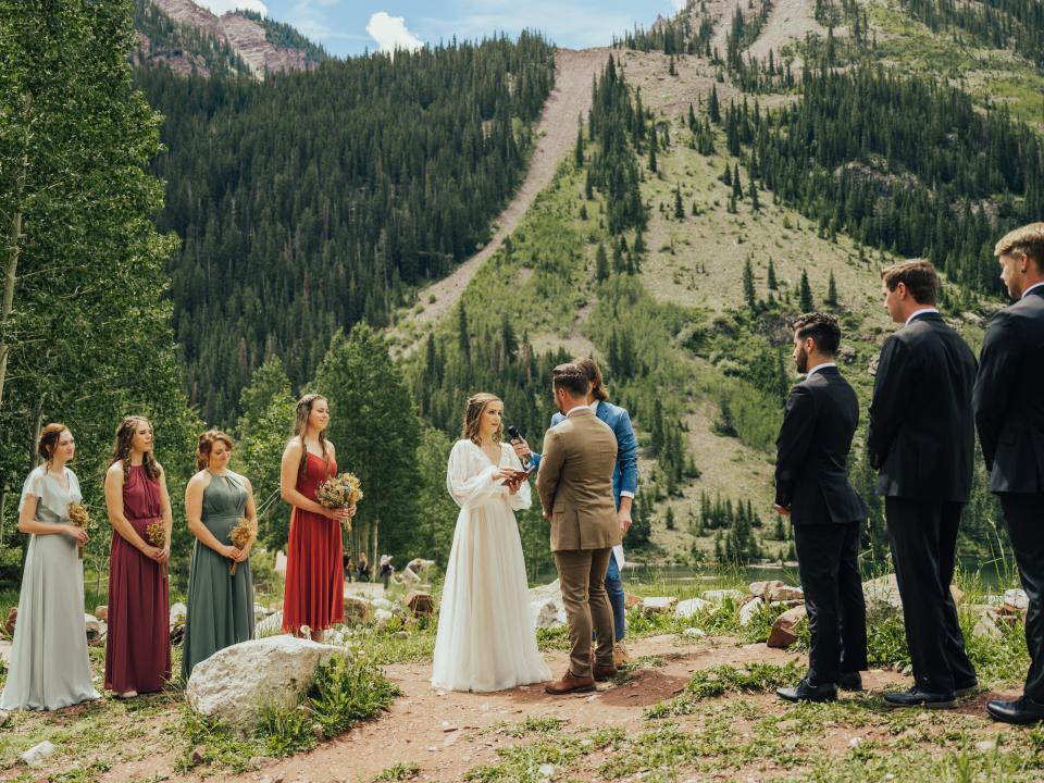 abi and her husband standing at their wedding ceremony with their bridal party