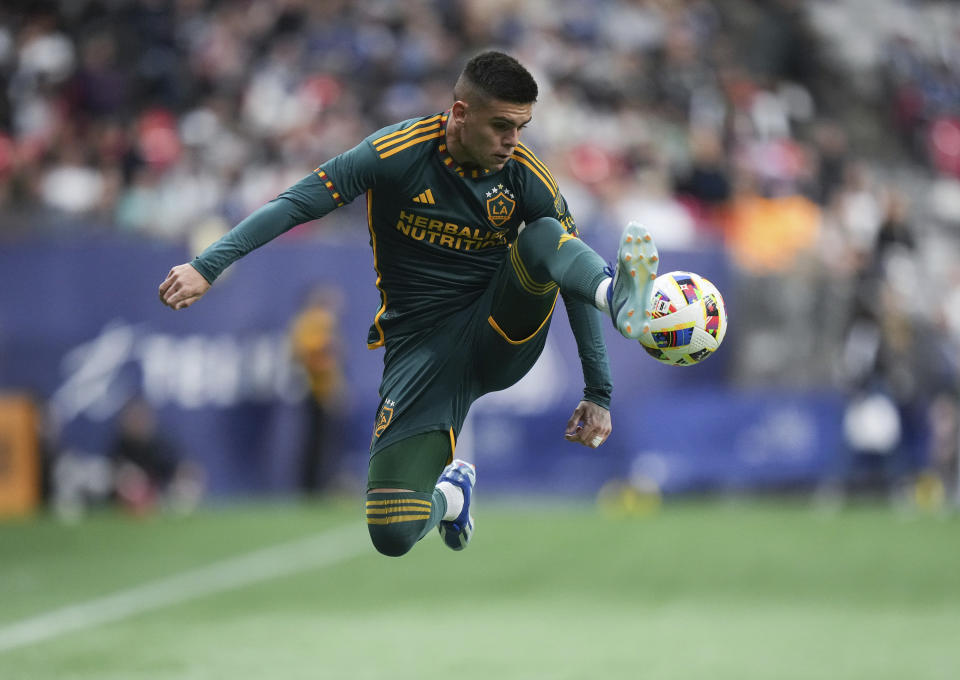 LA Galaxy's Gabriel Pec leaps to receive a pass during the first half of the team's MLS soccer match against the Vancouver Whitecaps on Saturday, April 13, 2024, in Vancouver, British Columbia. (Darryl Dyck/The Canadian Press via AP)