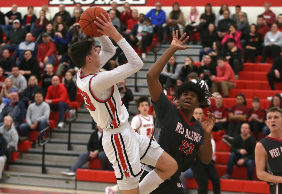 Moon's Michael Santicola (23) attempts a two point shot over the head of West Allegheny's Brandon Bell (23) during the first half Tuesday night at Moon Area High School.