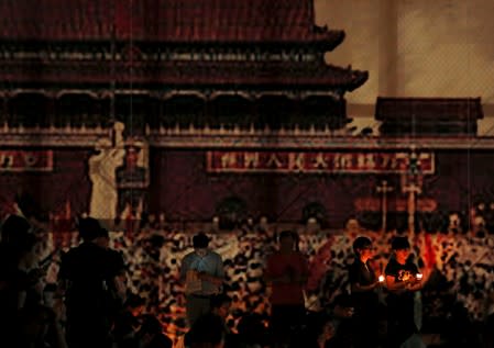 FILE PHOTO: Pro-democracy supporters hold candles underneath a banner featuring a scene at Beijing's Tiananmen Square in 1989, during an annual candlelight vigil at Victoria Park in Hong Kong