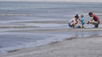 William and Kayla Darling play with their son King along the Great Salt Lake Tuesday, June 15, 2021, near Salt Lake City. Salt Lake City set another heat record Tuesday, June 15, 2021, and experienced its hottest day of the year as the state's record-breaking heat wave persists. Utah's capitol hit 104 degrees, breaking the previous heat record for that date of 103 degrees, according to information from the National Weather Service. On Monday, Salt Lake City hit 103 degrees to break a heat record for that date set nearly 50 years ago. (AP Photo/Rick Bowmer)