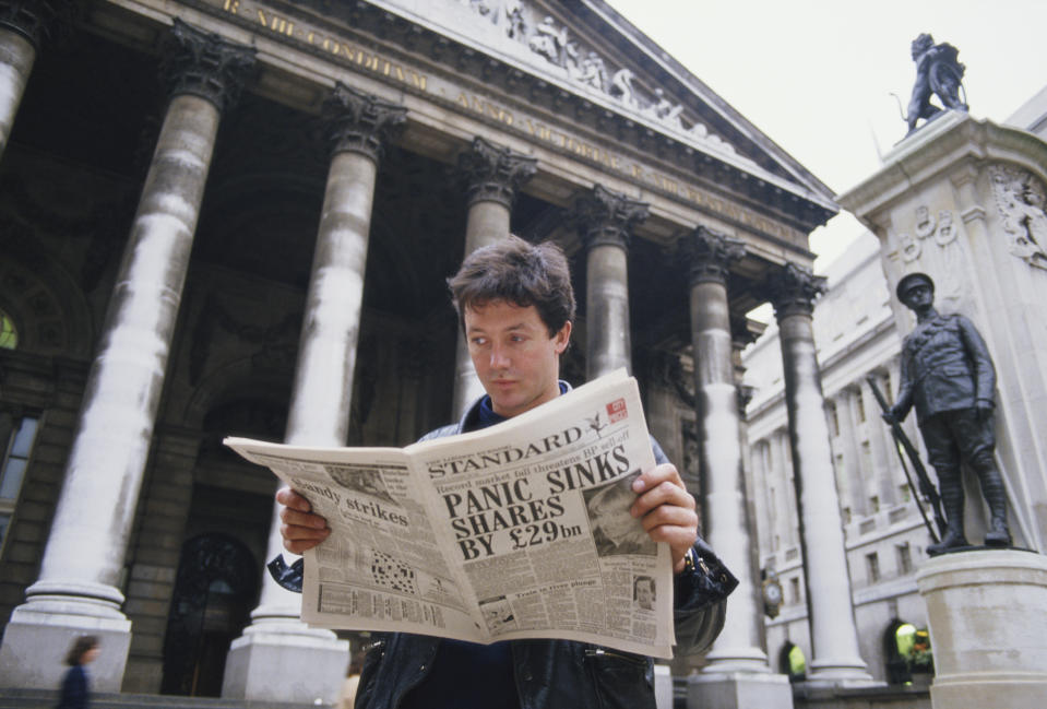 A young man reads a copy of the Evening Standard outside the Royal Exchange in London, with a headline referring to that day's stock market crash, known as Black Monday, 19th October 1987. (Photo by Georges De Keerle/Getty Images)