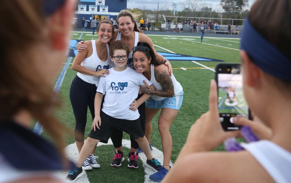 Liam Craane, then an 8-year-old battling Non-Hodgkin's lymphoma, was photographed in Oct. 2019 posing with John Jay field hockey coaches Samantha DeCosta, left, Kerri Roger, center, and Kristen Perry.
