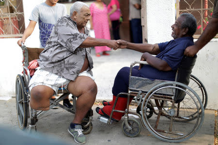 FILE PHOTO: Elimenes Fuenmayor, 65, a patient with kidney disease, greets another kidney disease patient, as they wait for the electricity to return during a blackout, in front of a dialysis centre, in Maracaibo, Venezuela April 11, 2019. REUTERS/Ueslei Marcelino