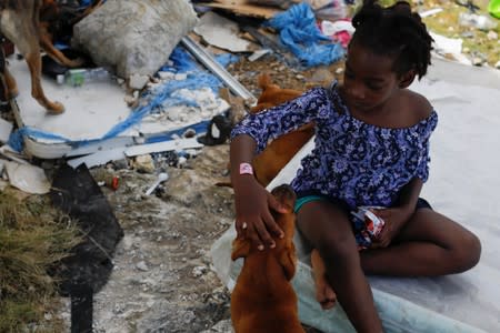 A girl pets her dog after Hurricane Dorian hit the Abaco Islands in Spring City