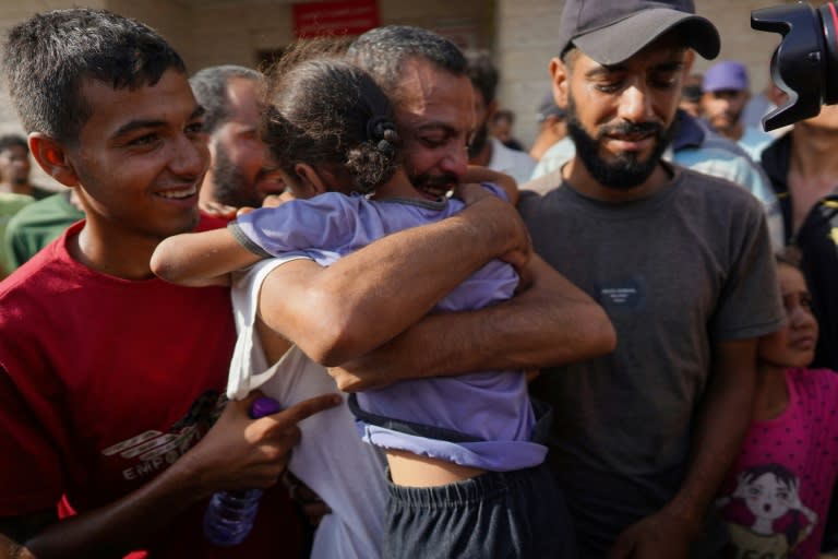 Un palestino que fue detenido por fuerzas israelíes abraza a una niña al ser recibido por familiares y allegados tras ser liberado para una revisión médica en un hospital de Deir al Balah, el 1 de julio de 2024 en el centro de la Franja de Gaza (Bashar Taleb)