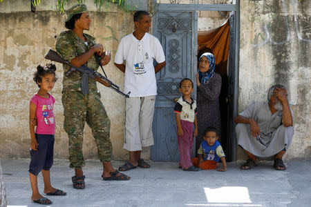 A member of Turkish-backed Free Syrian Army (FSA) is seen with local people in the border town of Jarablus, Syria, August 31, 2016. REUTERS/Umit Bektas