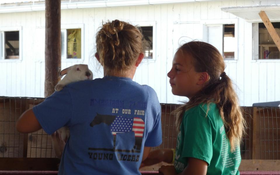 Two girls spend some time with their rabbits on Thursday at the 2022 Crawford County Fair.