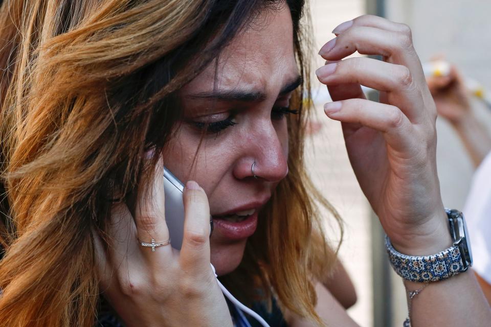 A woman cries as she talks on the phone.