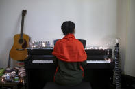 In this July 26, 2018 photo, Afghan musician Soraya Hosseini, a member of Arikayn rock band, plays piano in her house outside Tehran, Iran. The band made up of Afghan migrants plays Metallica-inspired ballads about the struggles of millions of Afghans who have fled to Iran to escape decades of war and unrest. Like others in Iran’s vibrant arts scene, they must contend with hard-liners who view Western culture as corrupt and object to women performing in public. (AP Photo/Ebrahim Noroozi)
