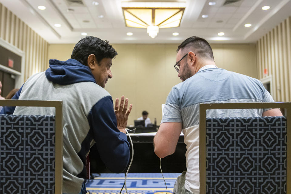 Mirle Shivashankar and Kevin Moch talk during a meeting of the word panel to finalize the 2023 Scripps National Spelling Bee words on Sunday, May 28, 2023, at National Harbor in Oxon Hill, Md. (AP Photo/Nathan Howard)