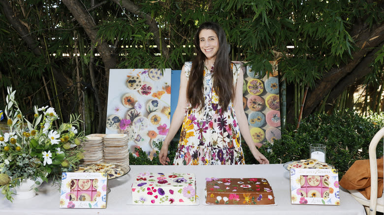Loria Stern smiling with edible flower cookies and cakes