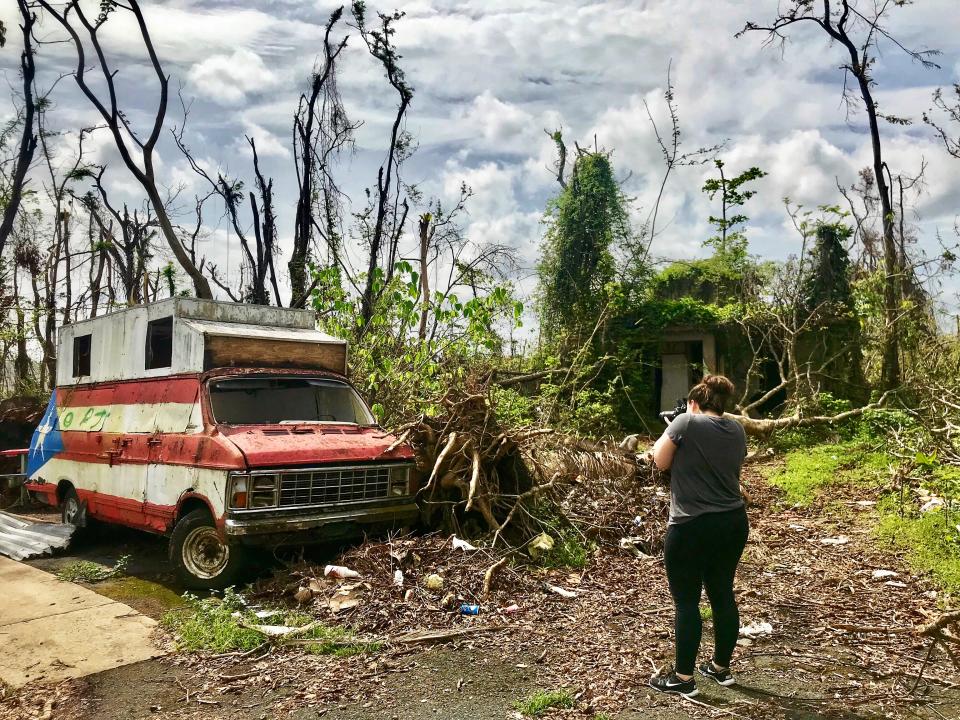 Megan Vazquez photographs the destruction around an abandoned van and hot dog stand near her hometown of Bayamón, Puerto Rico, three weeks after Hurricane Maria hit. (Photo: Caitlin Dickson/Yahoo News)