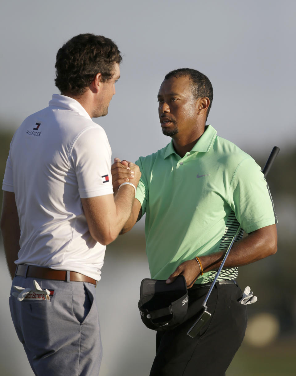 Tiger Woods, right, and Keegan Bradley congratulate each other after finishing the second round of the Honda Classic golf tournament, Friday, Feb. 28, 2014, in Palm Beach Gardens, Fla. (AP Photo/Wilfredo Lee)