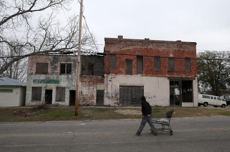 A pedestrian pulls a shopping cart by vacant buildings on March 6, 2015, in Selma, Ala. (Photo: Justin Sullivan/Getty Images)