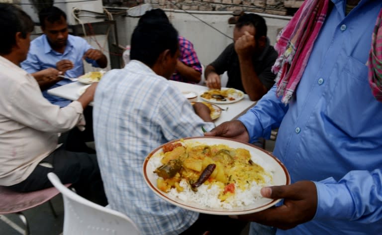 Indian workers from Bihar state eat lunch on the terrace of a hotel in New Delhi, after they were repatriated by the Indian government from Saudi Arabia