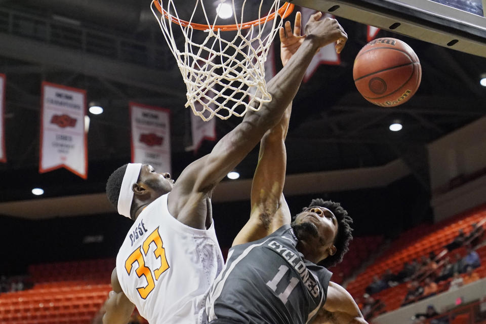 Oklahoma State forward Moussa Cisse (33) blocks a shot by Iowa State guard Tyrese Hunter (11) in the first half of an NCAA college basketball game Wednesday, Jan. 26, 2022, in Stillwater, Okla. (AP Photo/Sue Ogrocki)