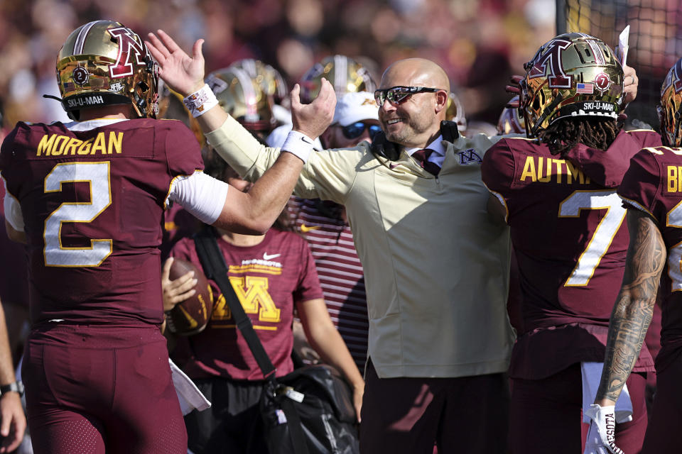 Minnesota head coach P.J. Fleck celebrates with quarterback Tanner Morgan and wide receiver Chris Autman-Bell (7) after Autman-Bell caught a touchdown pass against Colorado during the first half of an NCAA college football game, Saturday, Sept. 17, 2022, in Minneapolis. (AP Photo/Stacy Bengs)