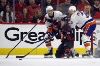 Carolina Hurricanes' Jake Guentzel (59) tries to gather in the puck between New York Islanders' Ryan Pulock (6) and Adam Pelech (3) during the first period in Game 1 of an NHL hockey Stanley Cup first-round playoff series in Raleigh, N.C., Saturday, April 20, 2024. (AP Photo/Karl B DeBlaker)