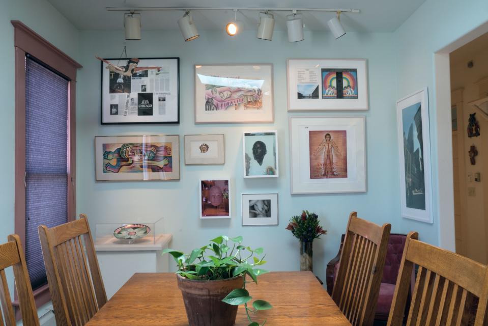 In the dining room, the painting in the center is from Kitty City, Chicago’s book of watercolors documenting a day in the life of their cats. To the right of it lies a sketch of the Liverpool, U.K., mural she designed for the 50th anniversary of the Beatles album Sgt. Pepper's Lonely Hearts Club Band. On the far right is Woodman’s photo of a couple kissing in front of Trump Tower, taken long before his election. He laughs, “Everybody has to have their Trump piece!”