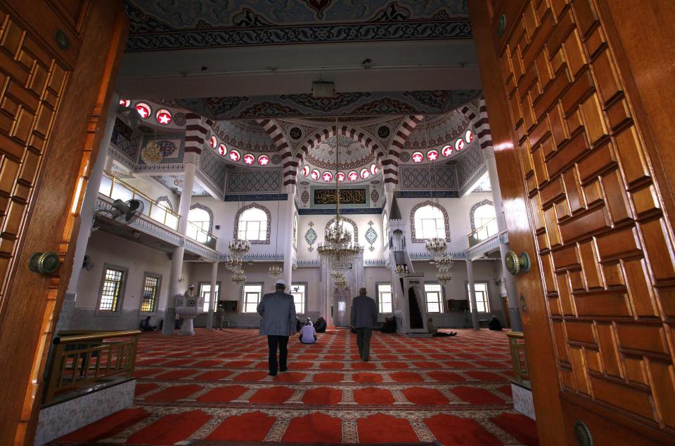 Muslim worshippers walk into the Gallipoli Mosque to pray in the western Sydney suburb of Auburn September 26, 2014. Last month, the national security agency raised its four-tier threat level to "high" for the first time and about 900 police launched raids on homes in Sydney's predominantly Muslim western suburbs and in Brisbane. Only about half a million people out of Australia's 23.5 million are Muslims, making them a tiny fraction in a country where the final vestiges of the "White Australia" policy were only abolished in 1973, allowing large scale non-European migration. At least half of Australia's Muslims live in Sydney's western suburbs, which were transformed in the mid-1970s from white working-class enclaves into majority-Muslim outposts by a surge of immigration from Lebanon. Picture taken September 26, 2014. To match Insight MIDEAST-CRISIS/AUSTRALIA REUTERS/David Gray (AUSTRALIA - Tags: RELIGION POLITICS)