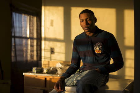 Damien Norman, 20, poses for a photograph in his apartment in the Bronx borough of New York, December 19, 2014. Norman says he was 17 years-old while imprisoned and awaiting trial on Rikers Island in 2012 for robbery. During his incarceration Norman says his wrist was broken during an incident involving a correctional officer and he was sent to solitary confinement immediately after. REUTERS/Elizabeth Shafiroff