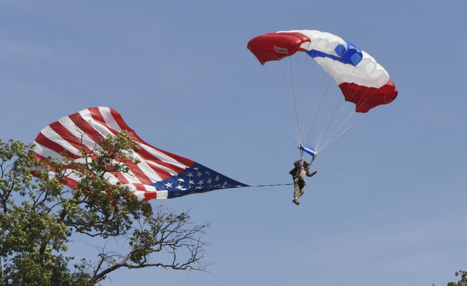 The American flag gets snagged by a tree as a member of the Frog-X Navy Seal Parachute team safely lands near the 18th green during the second round of the LIV Golf Invitational-Chicago tournament Saturday, Sept. 17, 2022, in Sugar Grove, Ill. (Joe Lewnard/Daily Herald via AP)