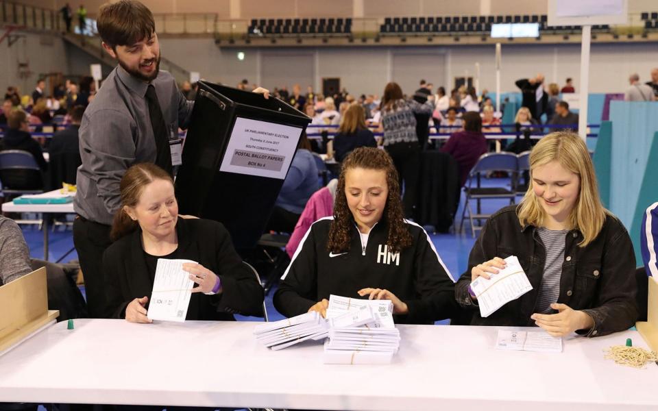 Election staff count postal ballot papers for the General Election, at the Emirates Arena in Glasgow - Credit: PA