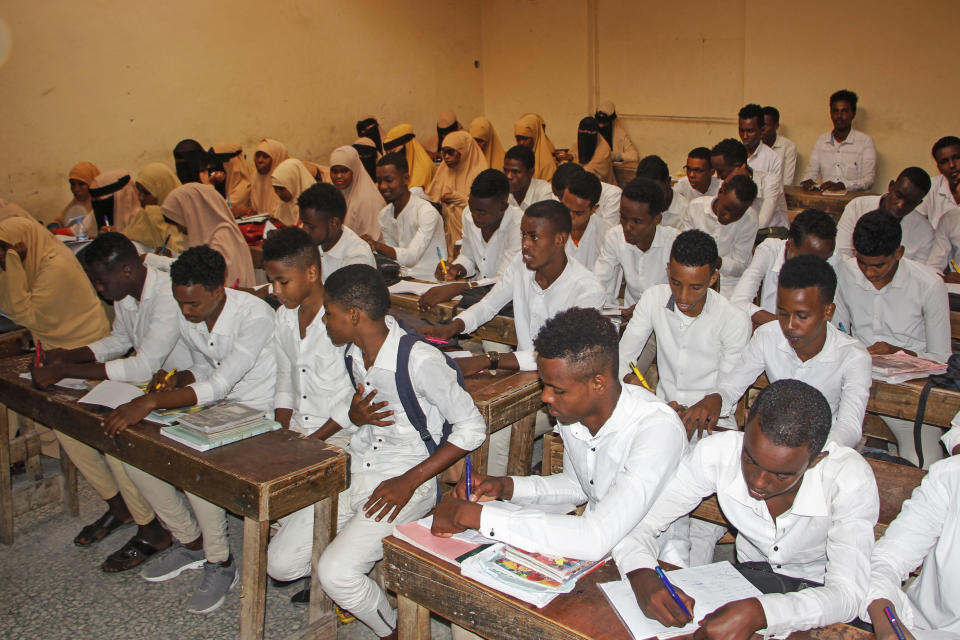 Somali schoolchildren finish their lessons at school before leaving to go home, after the government announced the closure of schools and universities and banned large gatherings, following the announcement on Monday of the country's first case of the new coronavirus, in the capital Mogadishu, Somalia Wednesday, March 18, 2020. For most people, the new coronavirus causes only mild or moderate symptoms such as fever and cough and the vast majority recover in 2-6 weeks but for some, especially older adults and people with existing health issues, the virus that causes COVID-19 can result in more severe illness, including pneumonia. (AP Photo/Farah Abdi Warsameh)