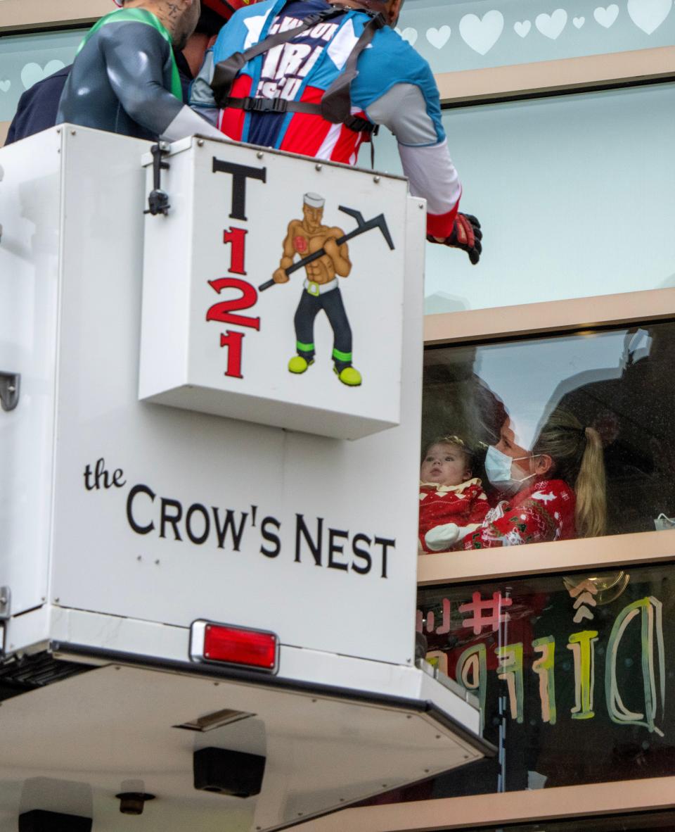 Dressed as Santa Claus, superheroes and video game characters, members of the Milwaukee and St. Francis Fire departments use bucket trucks to visit young patients and their families Monday at Children’s Hospital of Wisconsin in Wauwatosa.
