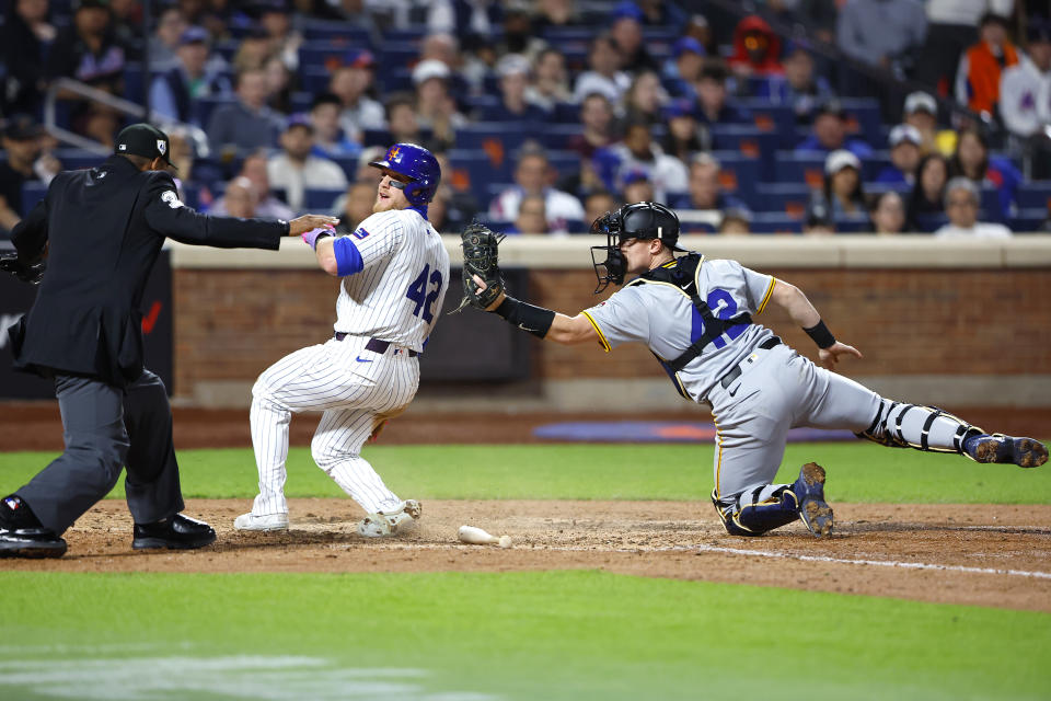 New York Mets' Harrison Bader, second from left, scores after Pittsburgh Pirates catcher Henry Davis, right, missed a tag at home plate during the eighth inning of a baseball game, Monday, April 15, 2024, in New York. (AP Photo/Noah K. Murray)