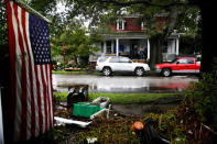 An American flag hangs across the street as people clean their house after the passing of Hurricane Florence in New Bern, North Carolina, U.S., September 16, 2018. REUTERS/Eduardo Munoz