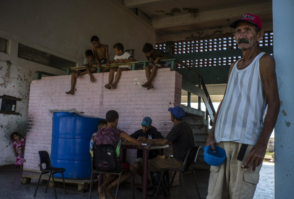 A resident left homeless by Hurricane Ian holds an empty bowl as he waits for his turn to eat at a school-turned-shelter in La Coloma, in the province of Pinar del Rio, Cuba, Wednesday, Oct. 5, 2022. (AP Photo/Ramon Espinosa)