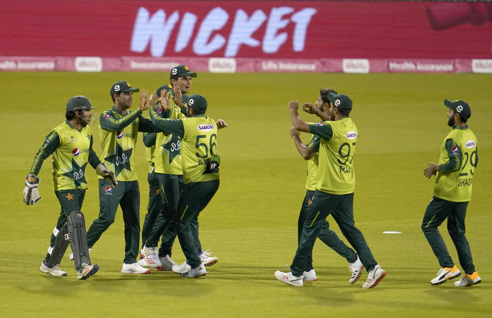 FILE - In this Tuesday Sept. 1, 2020, file photo, Pakistan players celebrate the dismissal of England's Dawid Malan during the third Twenty20 cricket match between England and Pakistan, at Old Trafford in Manchester, England. Six members of the Pakistan cricket squad in New Zealand have tested positive, Thursday Nov. 26, 2020, for COVID-19 and have been moved from managed isolation into quarantine. (AP Photo/Jon Super, Pool,File)