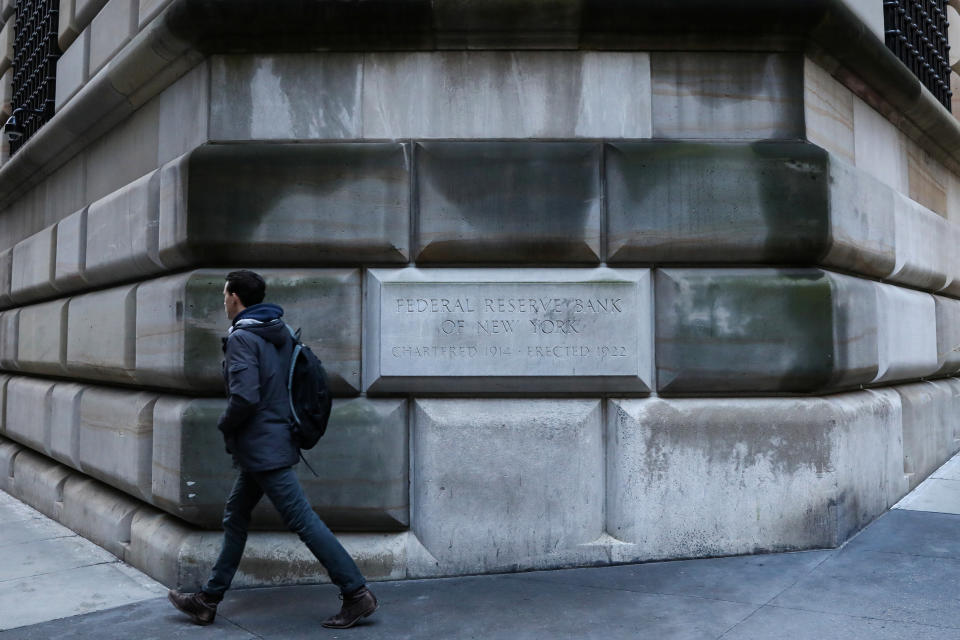 A man passes by the corner stone on the Federal Reserve Bank of New York in the financial district in New York City, U.S., March 4, 2019. REUTERS/Brendan McDermid