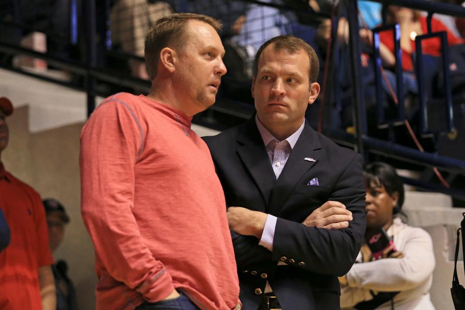 Mississippi football coach Hugh Freeze talks with Mississippi athletic director Ross Bjork during a men's basketball game between the Rebels and the Troy Trojans at the Tad Smith Coliseum on Dec. 22, 2015.