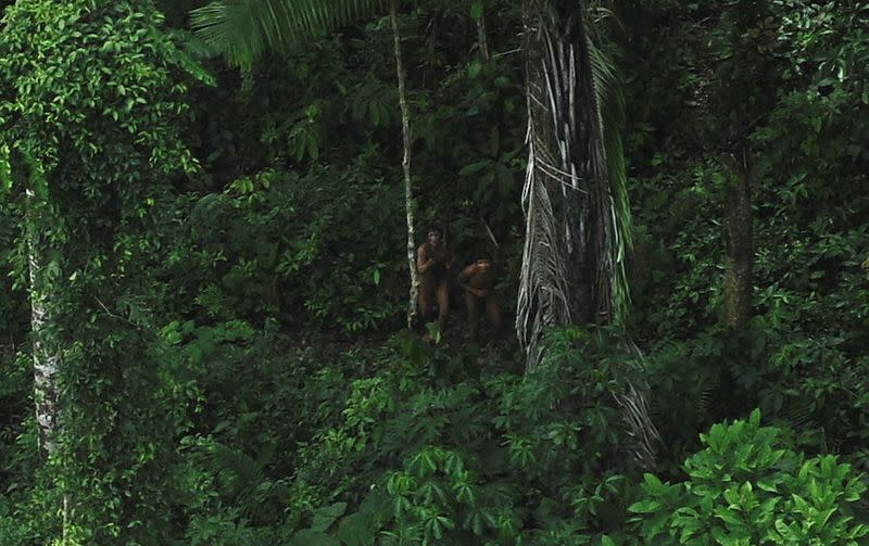 FILE PHOTO: Uncontacted indigenous react to a plane flying over their community in the Amazon basin