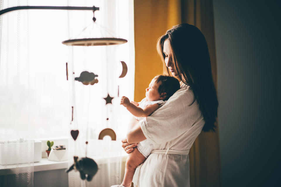 Young mother puts her baby to sleep while she cries. Concept photo parenthood and motherhood.  work