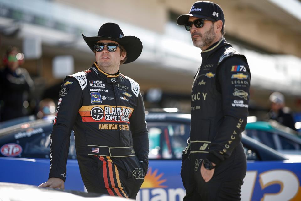 El piloto de Legacy Motor Club, Noah Gragson, a la izquierda, habla con el copropietario del equipo, el piloto Jimmie Johnson, en el Circuito de las Américas en Austin, Texas, el 25 de marzo de 2023.