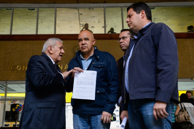 Venezuelan opposition spokesman of the Democratic Unity Roundtable (MUD) Jesus Torrealba (R) leave the National Electoral Council in Caracas on June 28, 2016