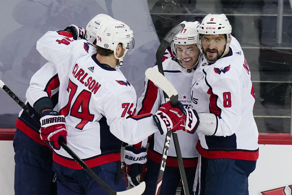 Washington Capitals' Alex Ovechkin (8) and John Carlson (74) celebrate with T.J. Oshie after Oshie scored a goal during the first period of an NHL hockey game against the New Jersey Devils Sunday, April 4, 2021, in Newark, N.J. (AP Photo/Frank Franklin II)