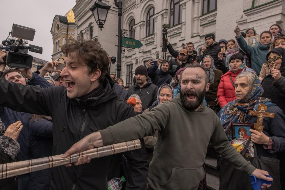 Ukrainian activists argue with believers of the Ukrainian Orthodox Church who block a door of a building to not let Ukrainian officials to enter (Getty Images)