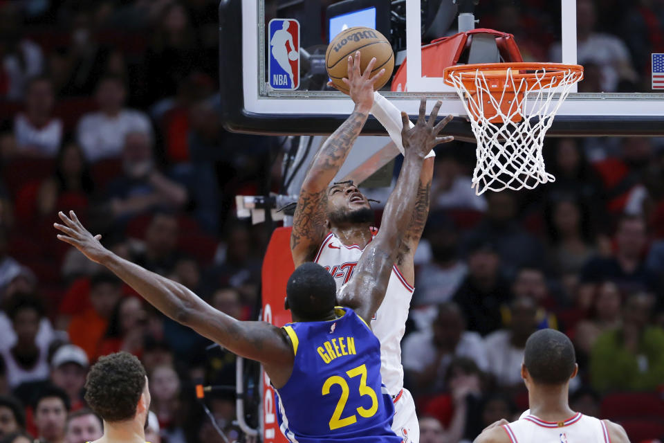 Houston Rockets forward Cam Whitmore, top, goes up to shoot in front of Golden State Warriors forward Draymond Green (23) during the second half of an NBA basketball game Thursday, April 4, 2024, in Houston. (AP Photo/Michael Wyke)