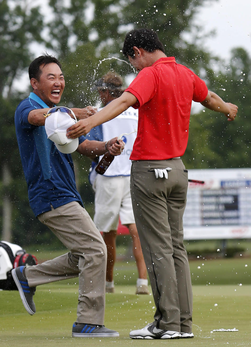 South Korean golfer Charlie Wi douses Noh Seung-yul, right, with beer on the 18th green after Noh won the Zurich Classic golf tournament at TPC Louisiana in Avondale, La., Sunday, April 27, 2014.(AP Photo/Bill Haber)