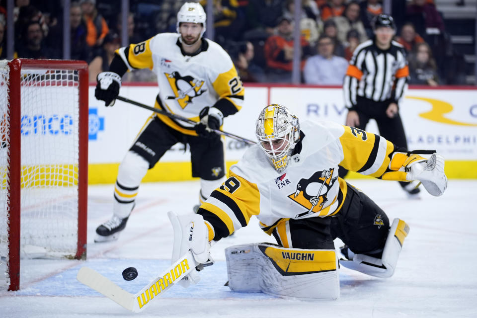 Pittsburgh Penguins' Alex Nedeljkovic reaches for the puck during the second period of an NHL hockey game against the Philadelphia Flyers, Monday, Jan. 8, 2024, in Philadelphia. (AP Photo/Matt Slocum)