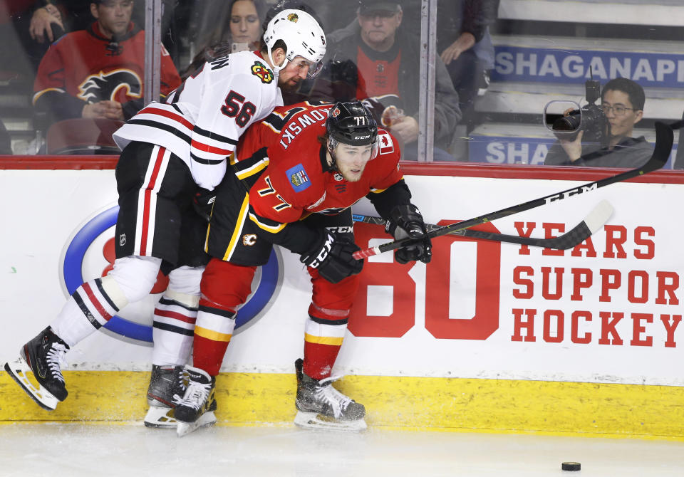 Chicago Blackhawks defenceman Erik Gustafsson (56) works against Calgary Flames center Mark Jankowski (77) during the third period of an NHL hockey game Saturday, Feb. 15, 2020, in Calgary, Alberta. (Larry MacDougal/The Canadian Press via AP)