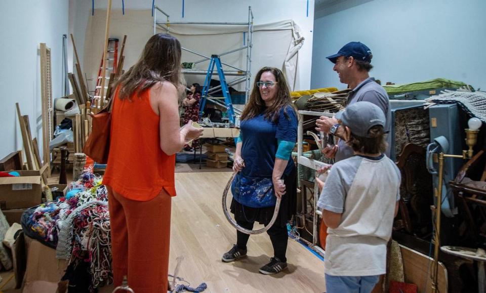 La artista Kerry Phillips guía a Leon Benoit Hurs y a sus padres, Cecilia García-Hurs y Pablo Hurs, de Texas, a través de los objetos que ha ido coleccionando a lo largo de los años mientras invita a los visitantes a observarla e interactuar con ella mientras construye la instalación de la pieza de su próxima exposición individual titulada "Kerry Phillips: Between the Mundane and the Miraculous" en The Bass Museum, en Miami Beach, que abrirá el 17 de agosto. el viernes 4 de agosto de 2023.