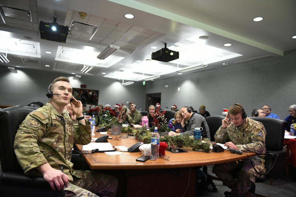 This image provided by the Department of Defense shows volunteers answering phones and emails from children around the globe during the annual NORAD Tracks Santa event on Peterson Air Force Base in Colorado Springs, Colo., Dec. 24, 2022. (Chuck Marsh/Department of Defense via AP)